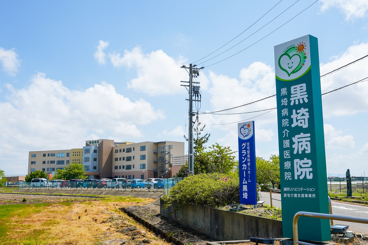 医療施設の外観。黄色と青のマルチカラー建物と施設標識が見える